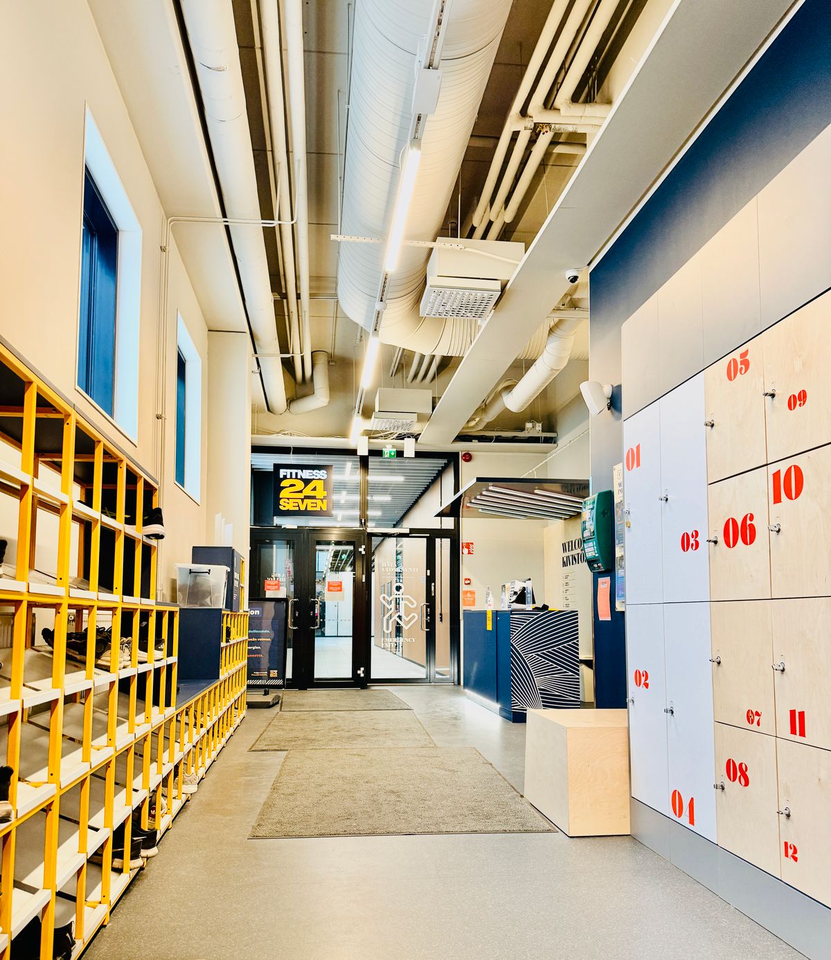 A modern gym entrance with lockers and a reception desk