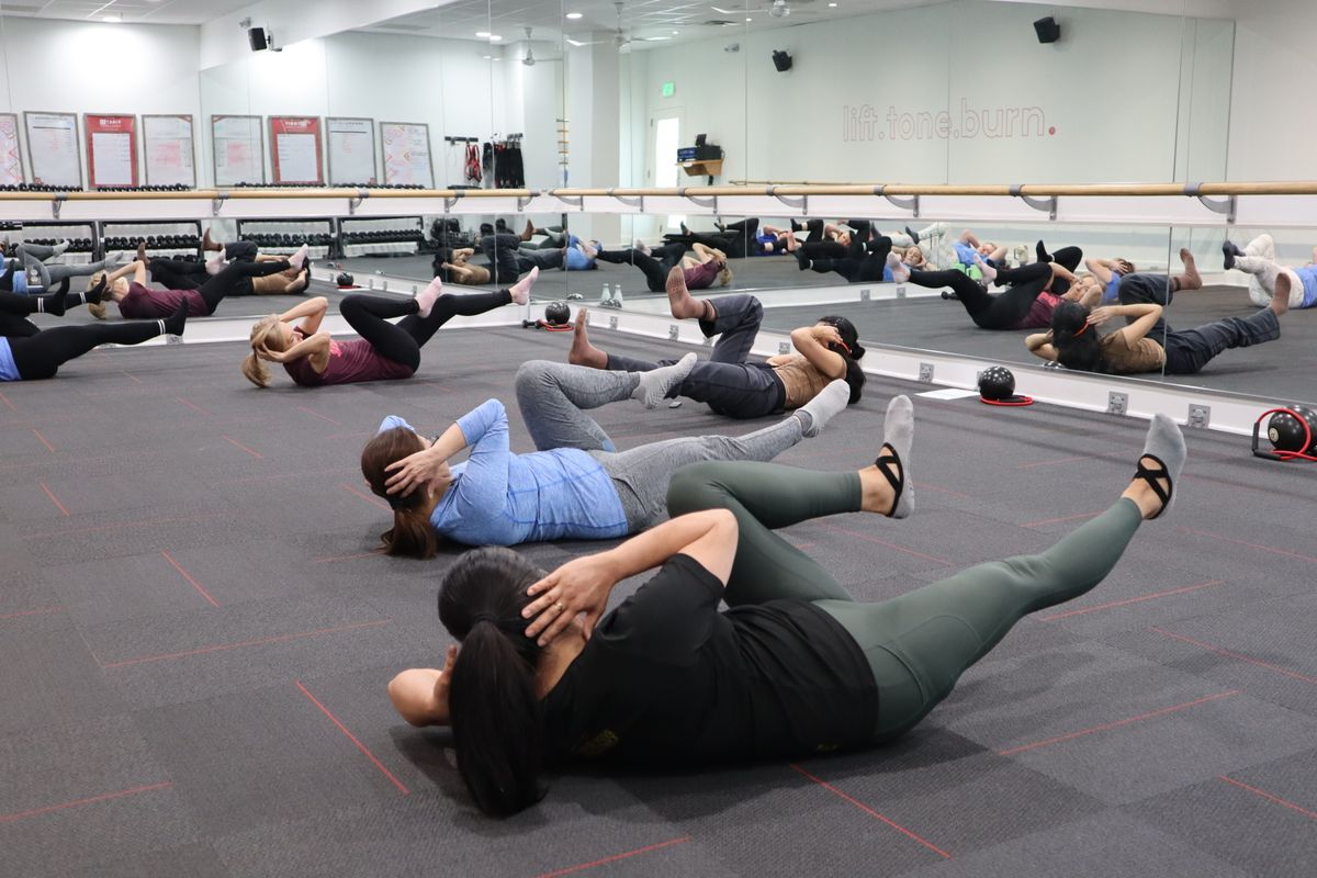 A group fitness class working out together in a modern gym studio
