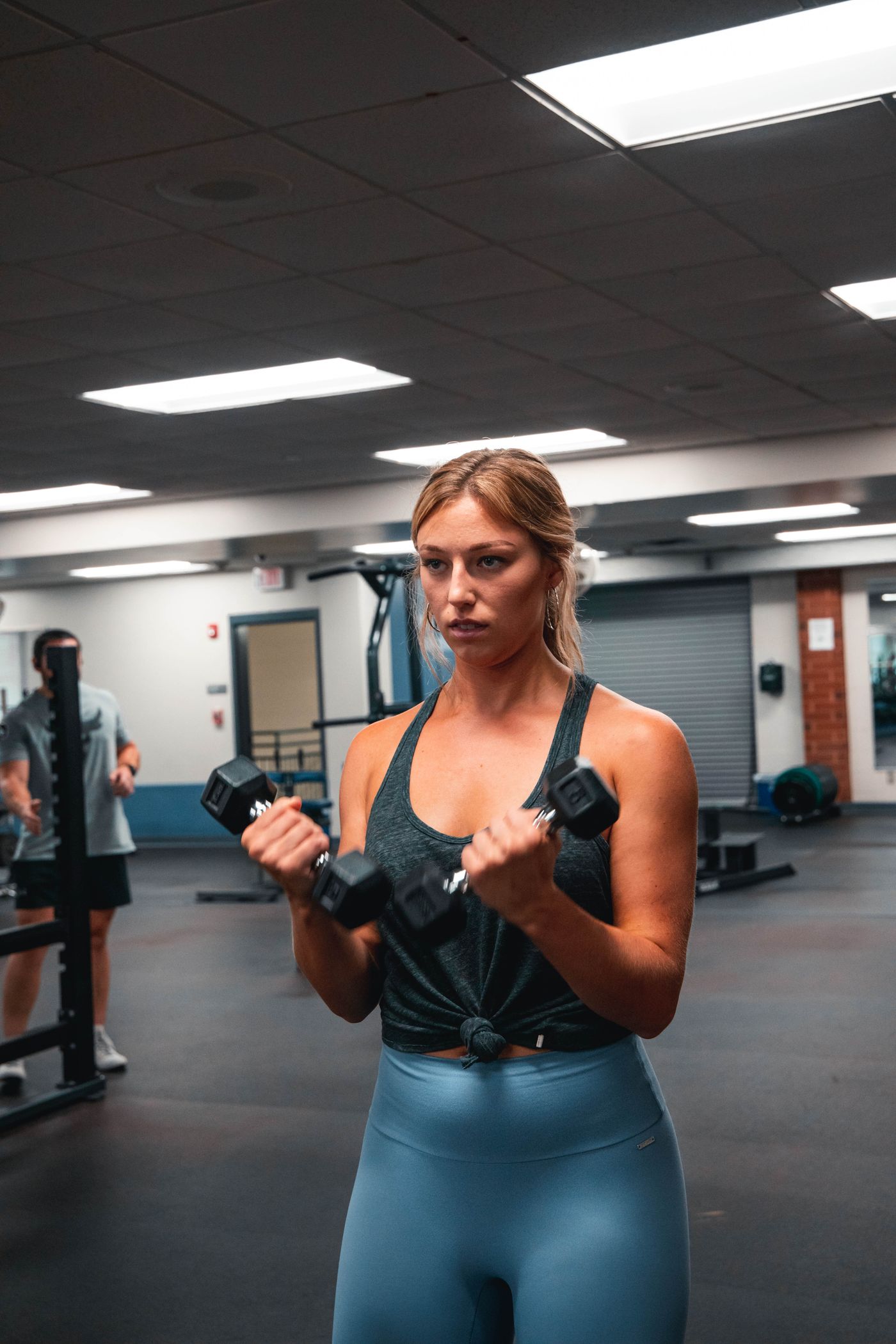 A member doing dumbbell curls in the gym