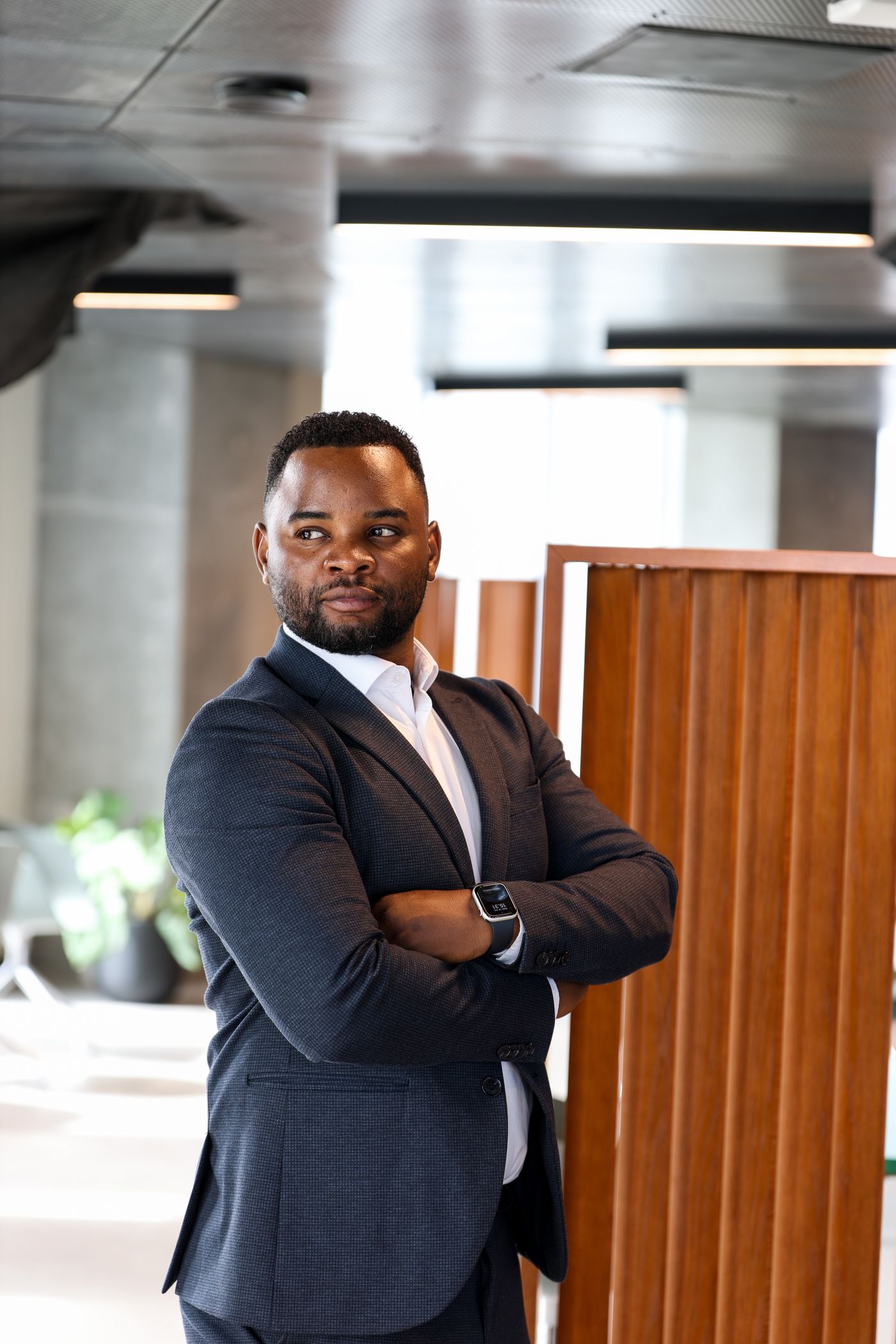 A gym owner in a suit standing with his arms crossed