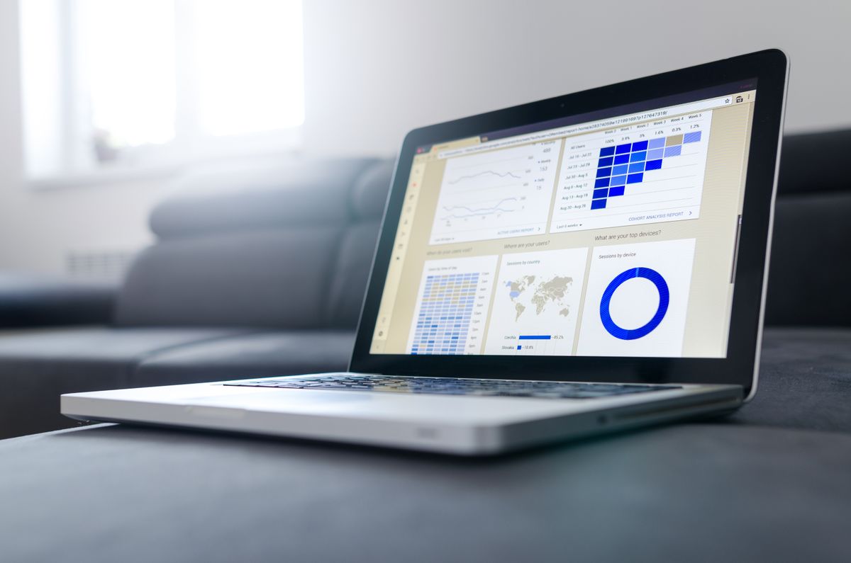 A laptop showing a reporting dashboard with charts