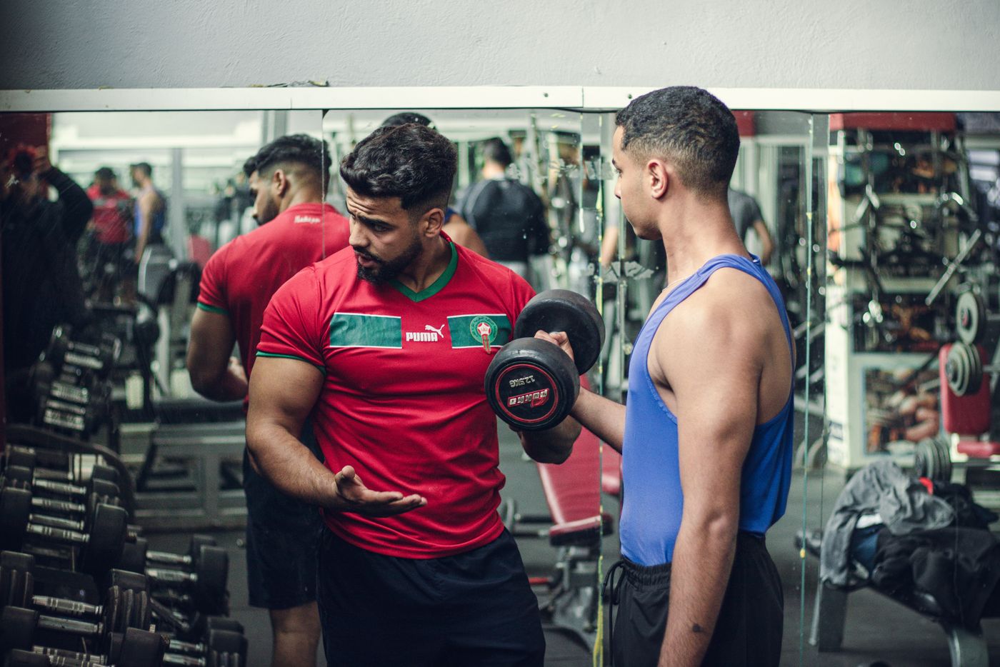 A trainer coaching a client with a dumbbell